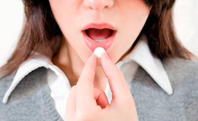 Девушка пьет таблетку