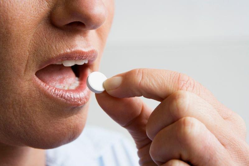 Человек принимает таблетку